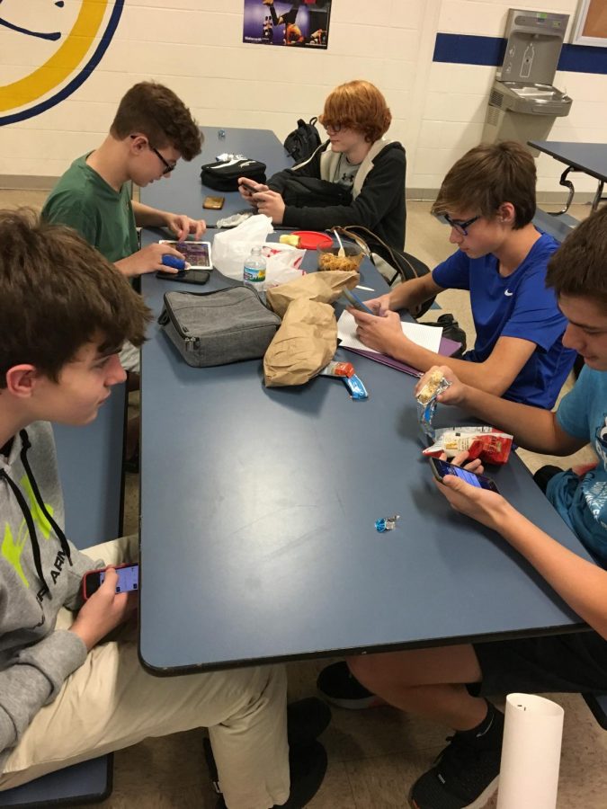 A group of Freshmen boys on their phones during lunch (PHOTO by Simpson)