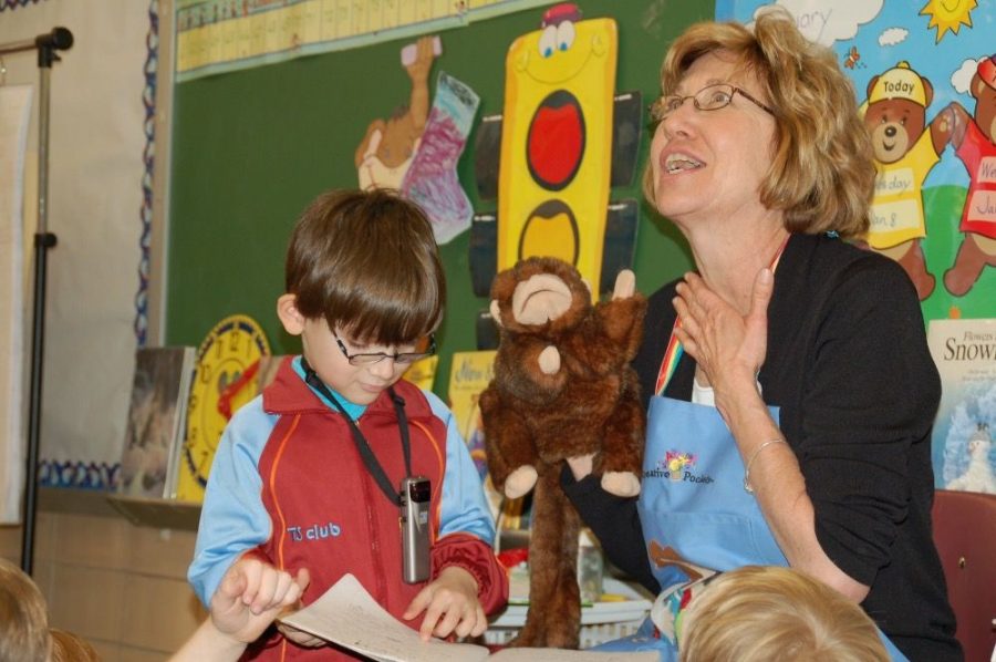 Concannon teaching reading to a little boy through the voice of Chester, the stuffed monkey. (PHOTO BY TPE YEARBOOK)