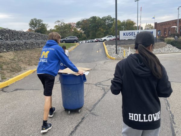 Mariemont students wheel recycling to the outside bins.